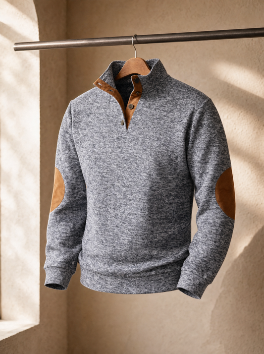 Light grey vintage polo with tan suede collar and elbow patches hanging from a metal rail