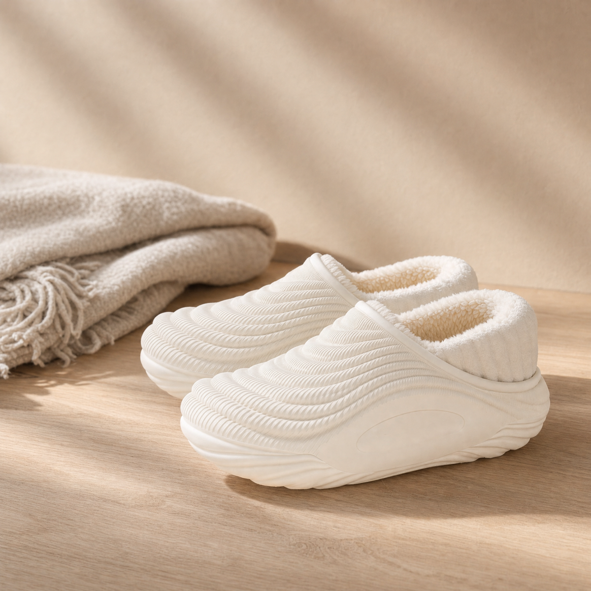 Waterproof indoor slippers in white on a pale oak floor