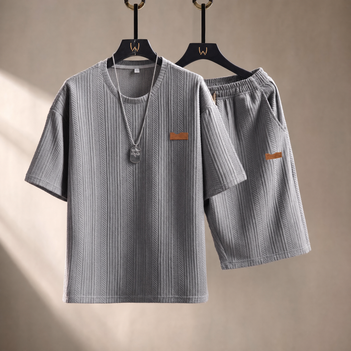 Men's sports two-piece set in gray on a warm studio backdrop